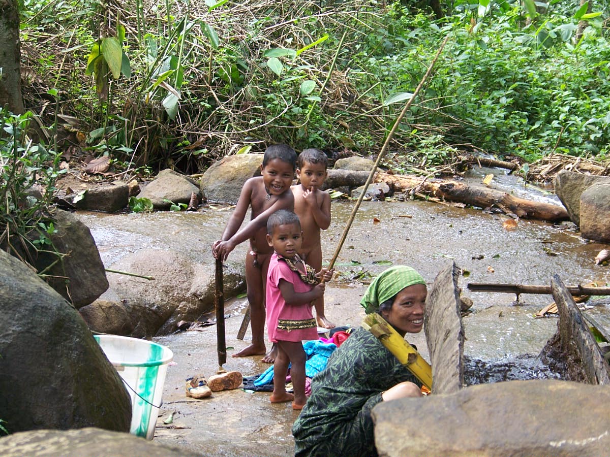Children enjoying their shower in a small stream amid the greens of our estate