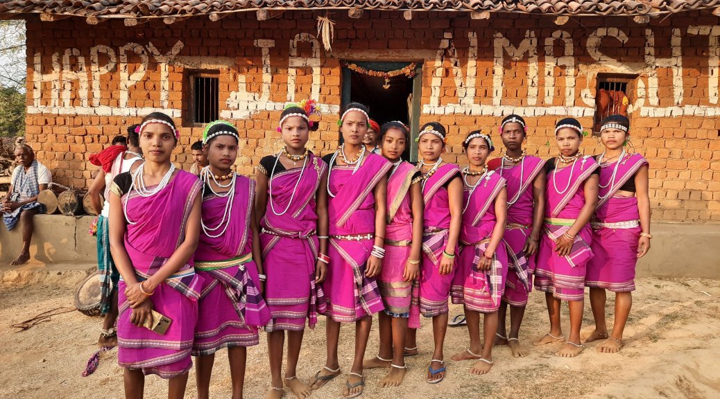 The Muriya girls with a Ghotul in the backdrop